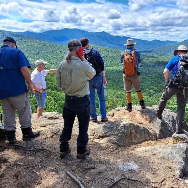 NHDES's tweet photo. Geologic mappers in Waterville Valley discussing how the last glaciation affected the area, for an upcoming surficial geologic map. #nhgeologicalsurvey #thisisnh #geology https://t.co/77JDc6tqSi