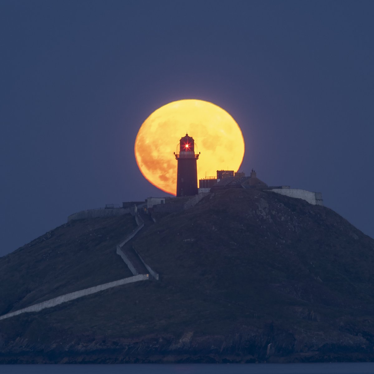 The moon rising behind Ballycotton Lighthouse, East Cork this evening.