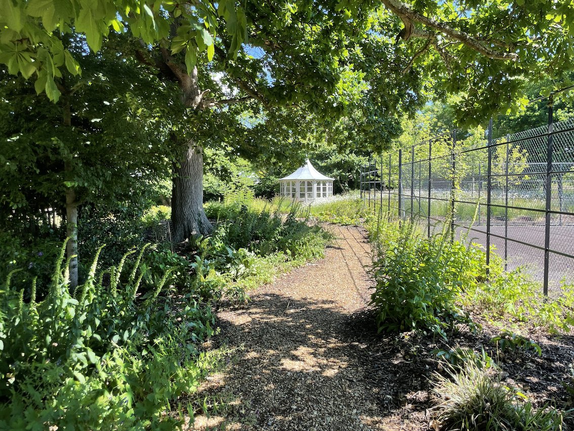 AFTER &amp; BEFORE.  When we first visited this large garden it was laid to lawn with a tennis court set within a pastoral landscape.  Our design included this meandering woodland walk alongside the tennis court leading to the summerhouse, orchard and meadow beyond.