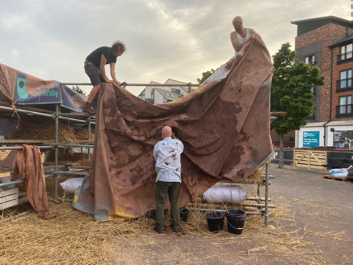 Billboard clay mixing - making cob from clay, straw, sand, water and our feet! The billboards were then draped like canvases atop scaffold drying racks. #HandEarthGestureReturn