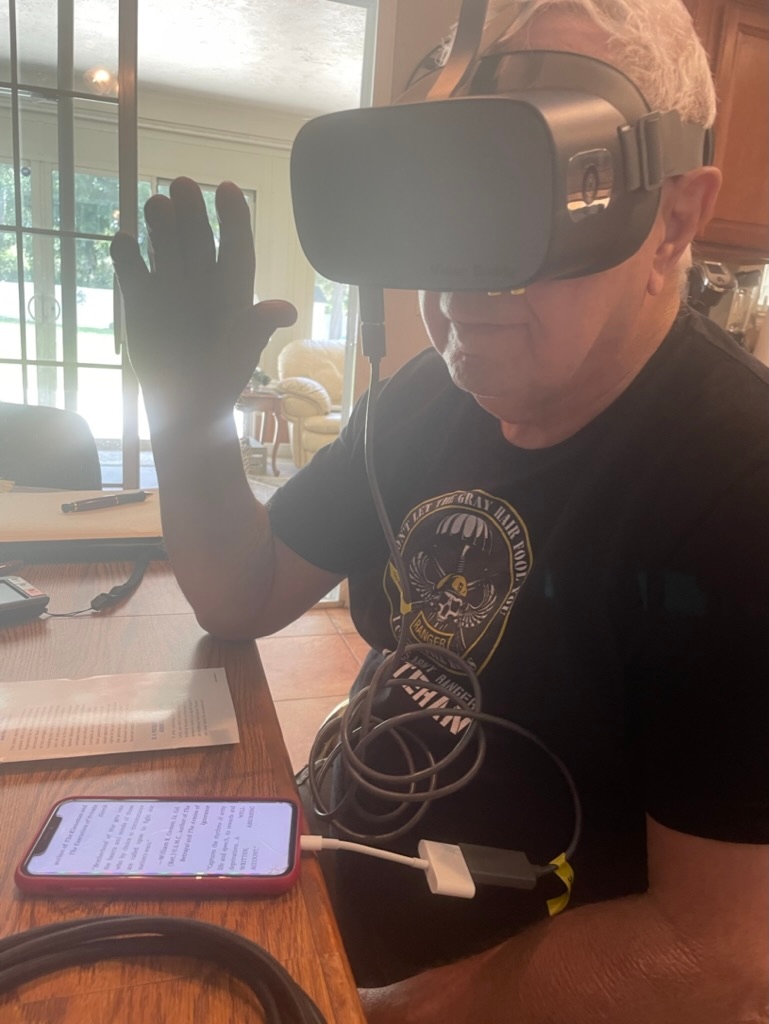 FLVISION's tweet photo. Otis, wanted to be able to read his Kindle books on his iphone. With the new accessories for the Vision Buddy, he is able to plug it into his phone, and is virtually seeing his iphone screen in the headset. He is currently rereading his favorite book from his younger years. https://t.co/vOT09DVAEj