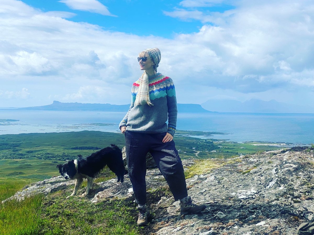 Tessadunlop's tweet photo. Posing. Last day. Arisaig (plus the Isle of Eigg) to offset @ionacraftshop knitwear - inc scarf and jersey. (They make their own wool don’t you know!) 

Dog belongs to mother, picture taken by brother @duncdunlop . Off to pack my case. 🥲
#westcoast #arisaig #mallaig #scotland https://t.co/Ahg1JY8TFs
