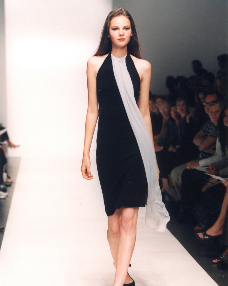 PaulaHian's tweet image. #FlashbackFriday #PaulaHian takes #Spring2001 #NewYorkFashionWeek @nyfw. Model wears a black halter dress with contrasting neckline draping on the runway.

#NYFW