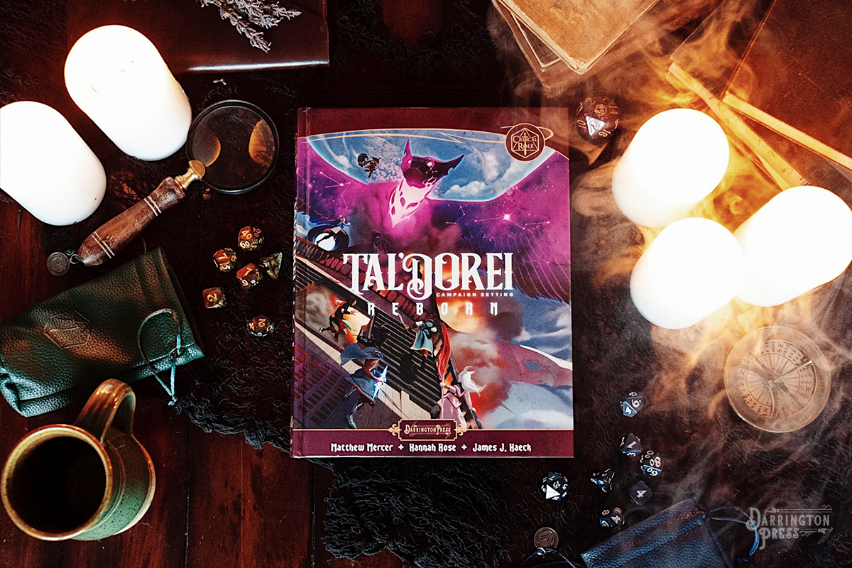 A photo of the sourcebook Tal'Dorei Campaign Setting Reborn on a table with candles, dice, a compass, a magnifying glass, and plenty of books.
