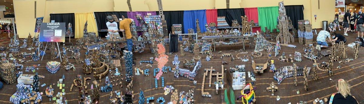 role_dice's tweet photo. #cardhalla is building up nicely! At the end of the convention people throw money at the towers to try knocking things down. All money raised is donated to the Patachou Foundation. #GenCon2022 https://t.co/xxfdYwcVXc