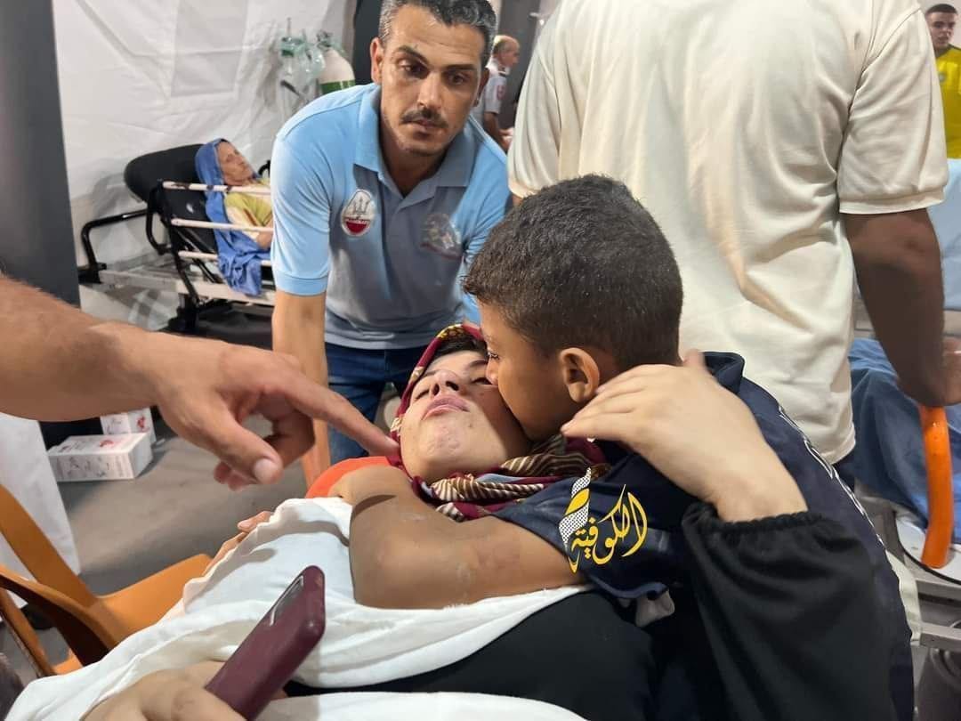 Media coverage: 'A Palestinian child kisses his mother who got injured in an Israeli airstrike on Rafah city, south of the #Gaza Strip.' #GazaUnderAttack