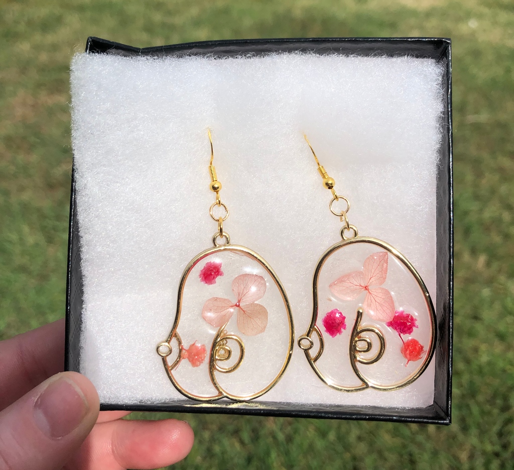 I love the pink flowers in this pair🌸

#resin #earringmaker #resinjewelry #earrings #statmentearrings #handmade #oneofakind

Image Description: an image of some statement earrings with a gold outline of breasts with small pink dried flowers encased in resin.