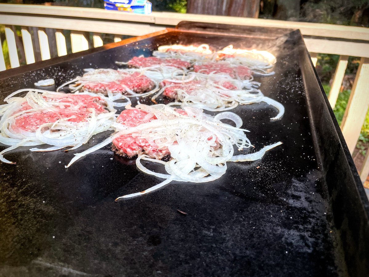 Smash burgers with white onions smashed into the top side.