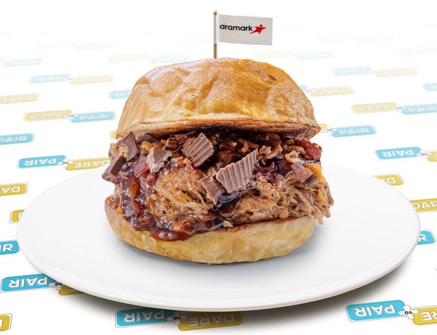 breakfasttv's tweet photo. The Kansas City Royals have unveiled a new handheld dish at their venue: The BBQ Reese’s Sandwich 🔥 The entree includes peanut butter cups, pulled pork, Sweet Baby Ray’s BBQ Sauce, and bacon.

Would YOU try this?

📸: @AramarkSports https://t.co/zTrHZZ4GXQ