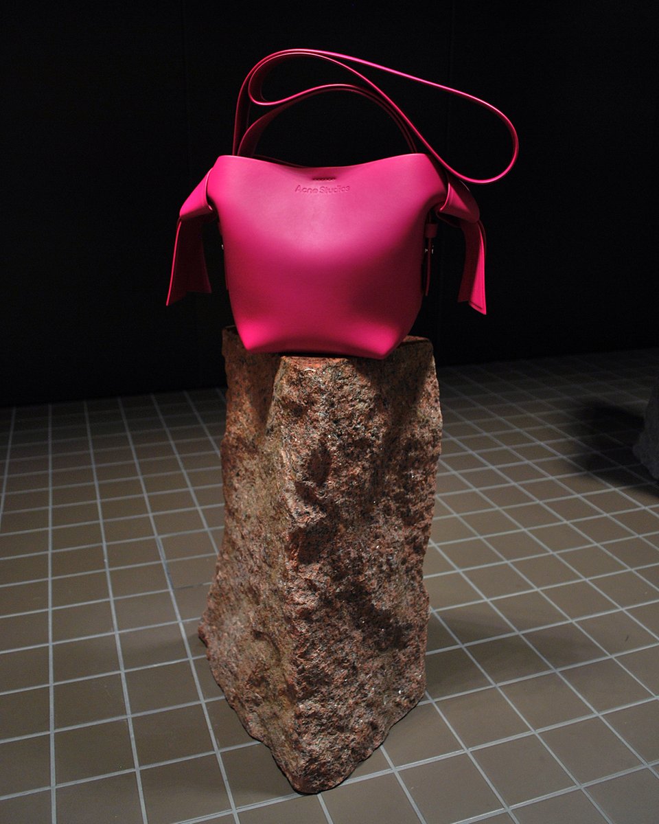acnestudios's tweet photo. Hot pink. A #Musubi bag balances on a monolithic sculpture by longtime #AcneStudios collaborator #DanielSilver at the entrance to our Stockholm headquarters. First created for our Nytorgsgatan store, the mannequins give the illusion of dance and movement, #InsideFloragatan. https://t.co/n69jZEhNTY