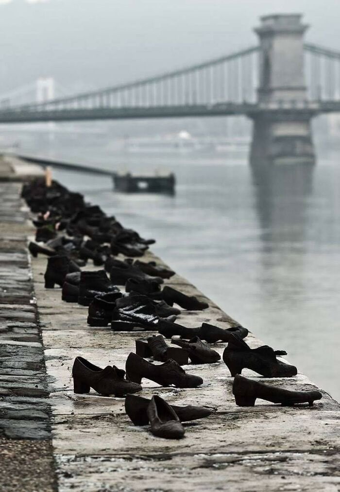 During WWII, Jews In Budapest Were Brought To The Edge Of The Danube, Ordered To Remove Their Shoes, And Shot, Falling Into The Water Below. 

60 pairs of iron shoes now line the river's bank, a ghostly memorial to the victims.