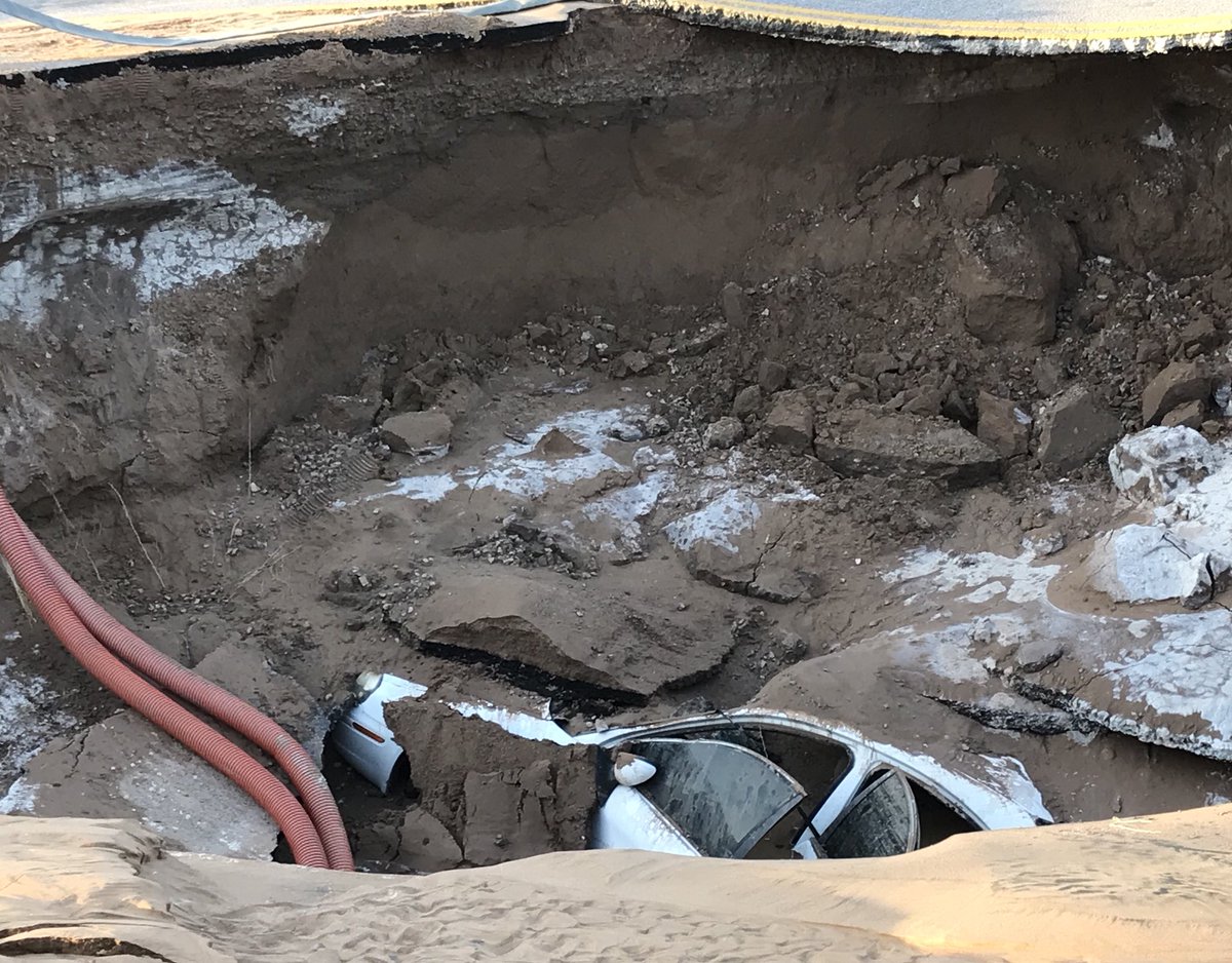 CBS4Photogs's tweet photo. A car remains at the bottom of the sinkhole on Yandell and Gateway. https://t.co/p6StHIU5AJ