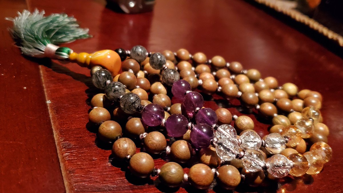 nonbinary power. phoebe silkwood on lavender and black silk; mookaite guru; steel gray silk tassel shot with emerald; pride colors in four varieties of natural quartz, incl. tourmalinated quartz. knotted in ceremony on mercury night, mercury hour. $93