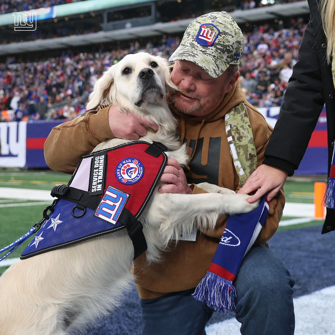 Giants's tweet photo. At today's game, 36-year US Navy Veteran John Mulvey - who served in Desert Storm, Haiti, the Gulf Wars, Iraq, Afghanistan, and during 9/11 recovery - was surprised with a service dog named Storm 🇺🇸 https://t.co/ZFzDiW0Xkq