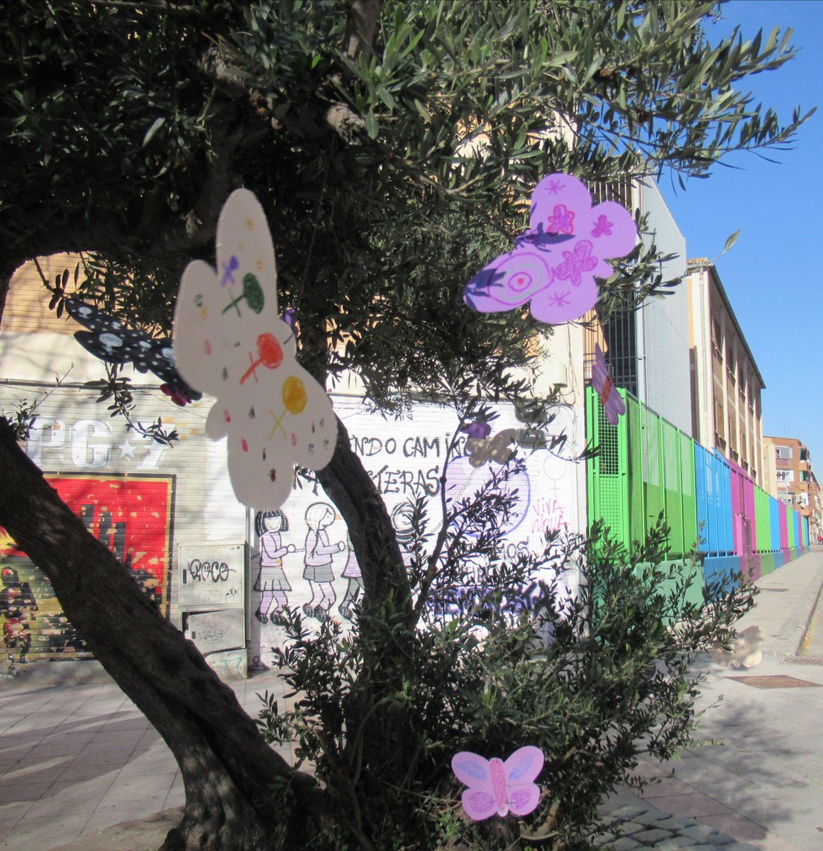 RedVVKFeminista's tweet photo. Estas mariposas pintadas por las peques del barrio poco a poci fueron inundando el olivo, simbolo del movimiento feminista del distrito https://t.co/rPcInVDUxR