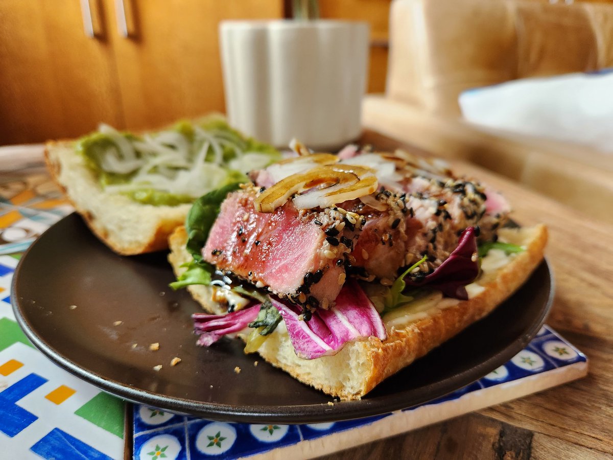 Lunch today was an ode to my favorite #Barcelona bistro @keikbarcelona. Their #fresh #tuna #sandwich defined my time in #Spain for many reason, ask me sometime. #tataki #atún #avocado #greens #mayo #balsamic #onion #sesame #ciabatta #pan #casero #thebombdotcom. #bcn #foodie