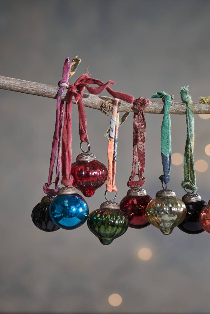DecoratorsNotes's tweet image. This set of twelve glass baubles will bring a welcome pop of colour to your home this Christmas. Each set contains a vibrant mix of colours and shapes, all in a versatile miniature size. Finished with recycled sari ribbons and presented in a cotton bag. Made from recycled glass.