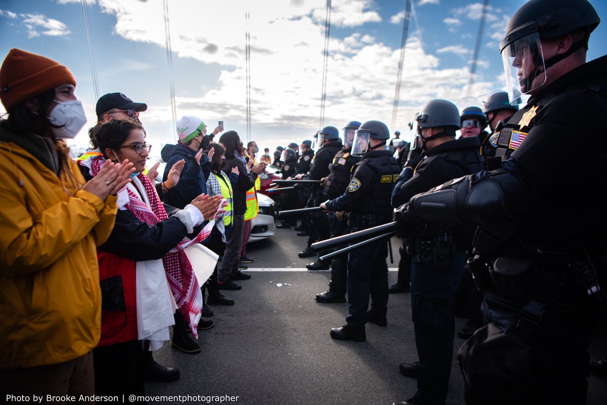 movementphotog's tweet photo. Protestors who shut down the #BayBridge today to call for a #ceasefire in #Gaza and an end to US military aid to Israel face down a line of riot cops. #Palestine #FreePalestine #CeasefireNow https://t.co/wMDC2ttMH4