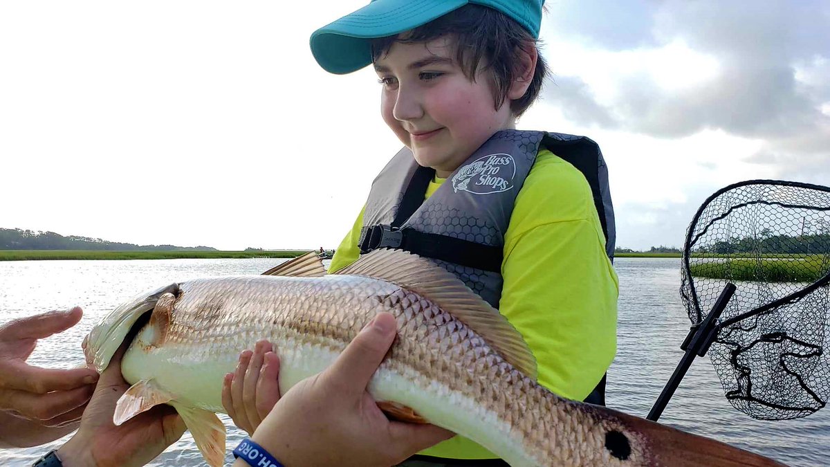 Seeing the fish emerge from the water, Caleb exclaimed, "Oh my goodness, this is huge! This has to be a redfish." God bless! #childswish #ussa #fishing #fishinglife #outdoors #DisabilityInclusion #fishingday #thisisfishing