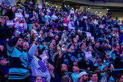 Photo of fans wearing Hockey Fights Cancer beanies and I Fight For signs provided by the Kraken and Virginia Mason Franciscan Health. 