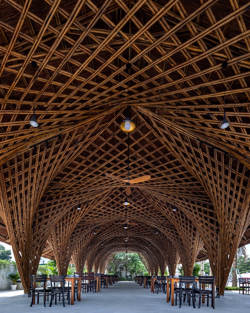 parametricarch's tweet photo. Keeng Seafood Restaurant, designed by BambuBuild, features conference halls, private dining rooms, a kitchen, a restroom, and a bamboo hall. The bamboo hall is particularly noteworthy for its boat-shaped thatched roof that is elegantly curved and supported by bamboo structures that resemble nipa palms.

The bamboo hall's ground floor plan is simple, accommodating up to 180 guests, with easy access and connection to the annex house. The owner wanted an impressive and environmentally friendly design that could be constructed quickly. The hall's hypar design allows for straight bamboo poles to create curved surfaces, resulting in an exceptional form without the need for bamboo bending. However, roofing with natural thatch is challenging due to the double curvature of the hypars, but the addition of trusses and purlins creates a two-layer structural roof, increasing the ceiling's appeal. 

📸Hyroyuki Oki

#bambubuild #parametricarchitecture #restaurant #vietnam #naturalmaterial #ecofriendly