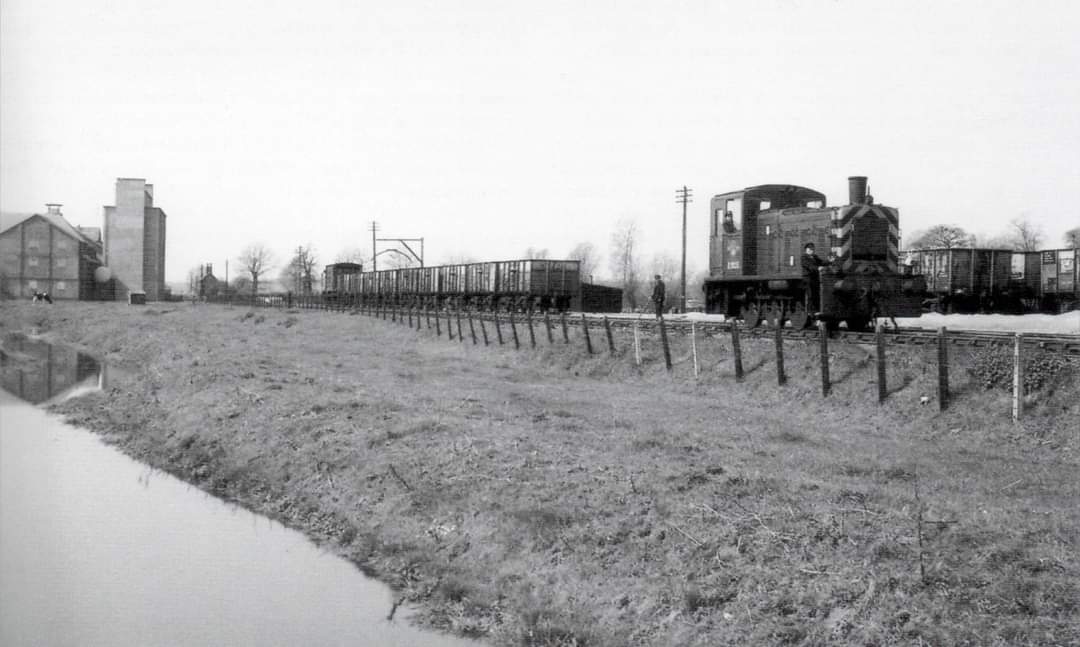 Shunting wagons at Ditchingham is Lowestoft-based BR Class 03 0-6-0 diesel shunter No. D2035 (03035) as viewed west towards Ditchingham Maltings (left) and the Norwich Road Gatekeeper's cottage in the distant left and just right of the maltings. 1/