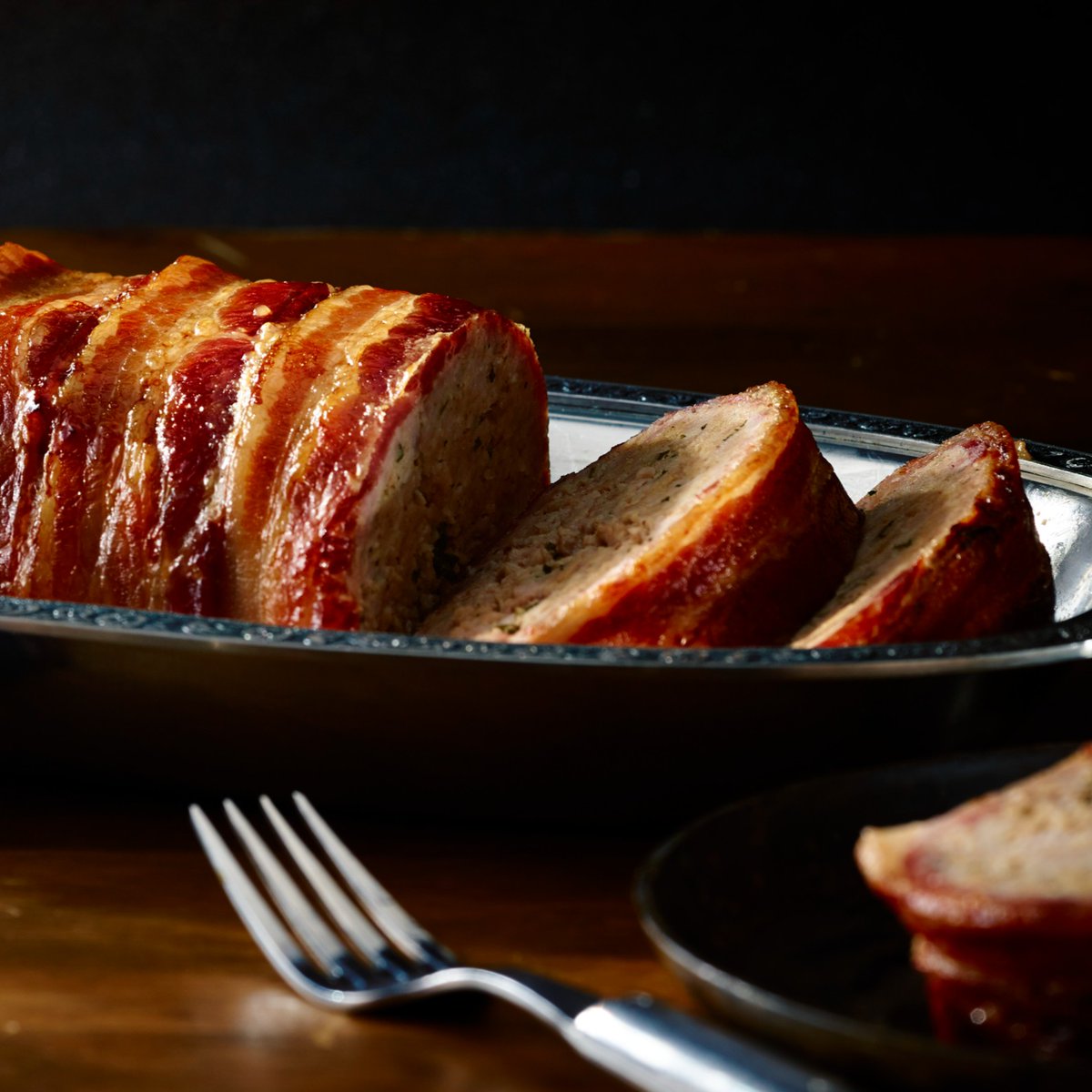 Whether you're gathered around the family table or hosting a special celebration, our Bacon-Wrapped Meatloaf is a star attraction that will please all palates. It's a classic dish reimagined with a smoky, savory dimension. bit.ly/463Fkw8