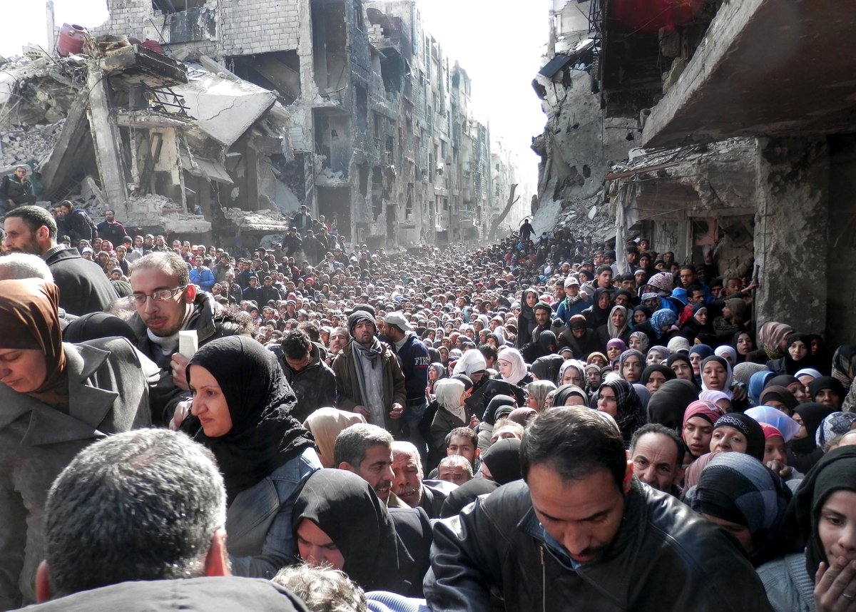 This is a horrific image of thousands of Palestinians waiting in line for food around ruins after the government destroyed their homes, killed thousands, and cut them off from all resources. You might not recognize it because it’s from Syria in 2014 so no marches.