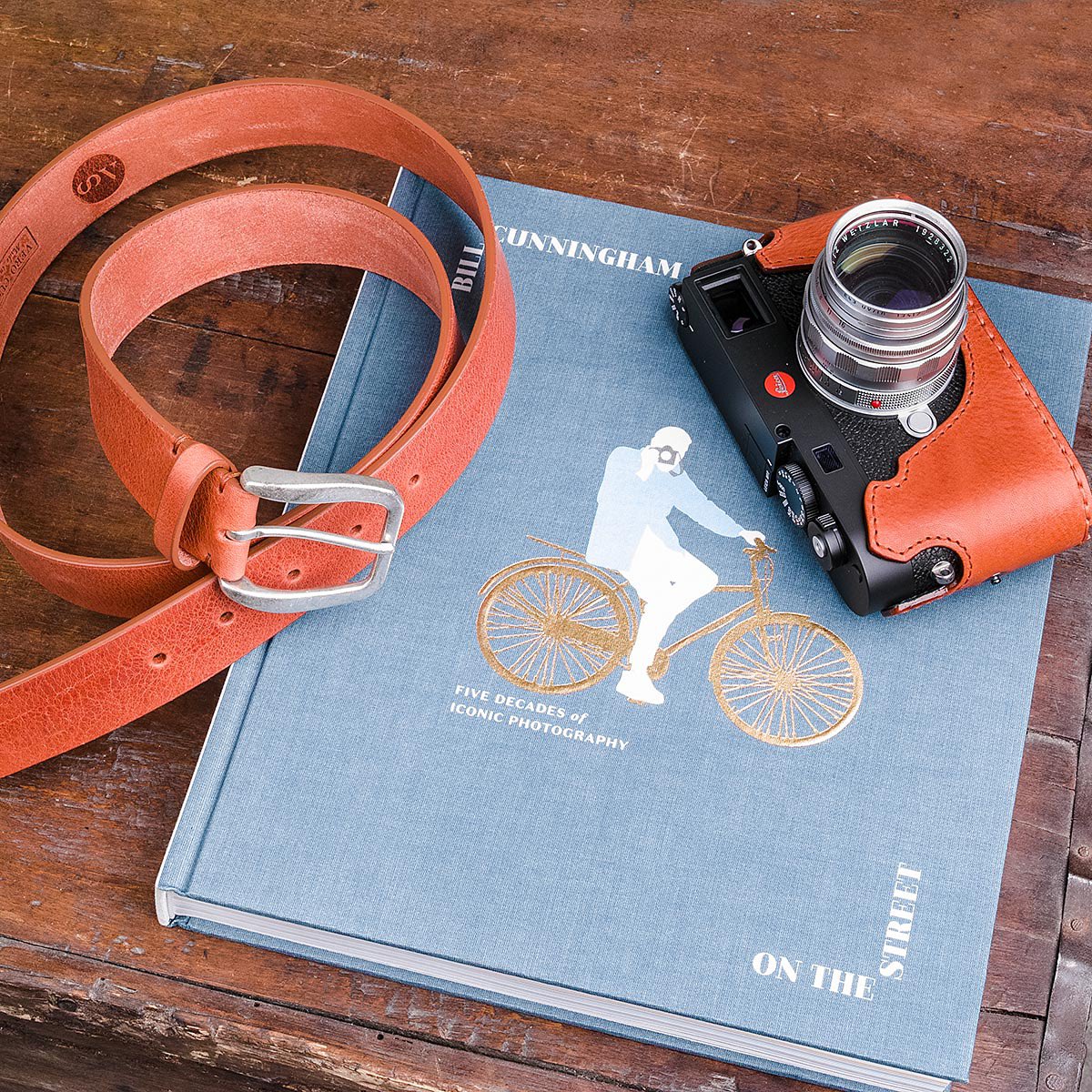 Great book #billcunningham about #streetstyle and #streetphotography . Our M11 with our belt and case in orange #leicam11