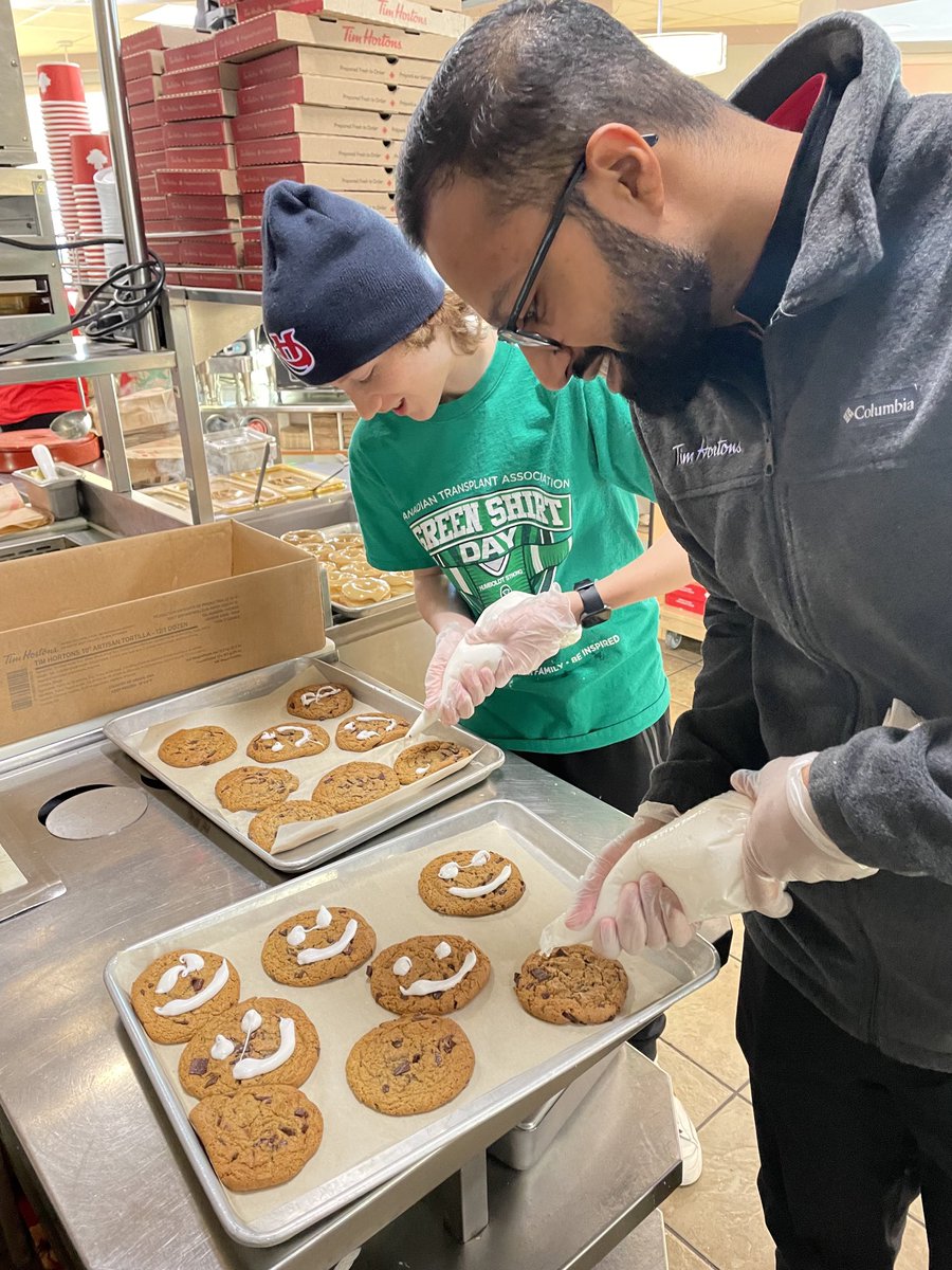TobyBoulet's tweet photo. I had to get tough as the Quality Control dude with Todd ⁦@LC_Kodiaks⁩ LOL!  The Smiles for the #HolidaySmileCookie keep rolling in as #GreenShirtDay shirts invade the Tims in Lethbridge! Thank you so very much to everyone for supporting local charities across Canada! 🙂🍪 https://t.co/F3bWjjBChL