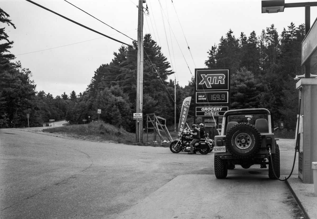 Baysville, Ontario, August. After I made the exposure, the driver of the Jeep drove off with the pump pistol still in the filler. A bit of gas spilled and there was much shouting. (Crown Graphic, 135mm f4.7 Xenar, Kodak TXP 320)