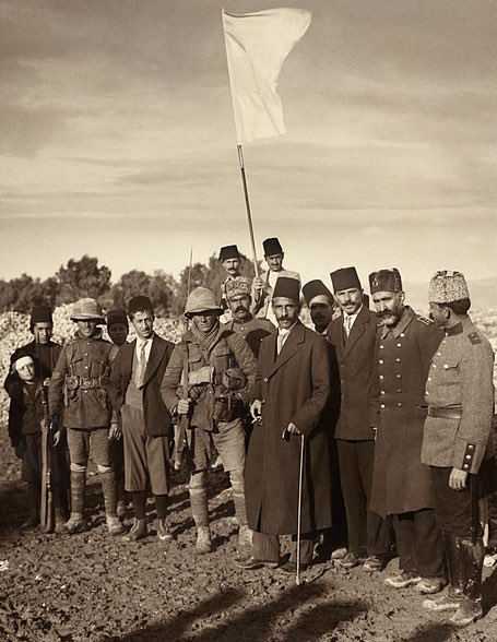 Columbuos's tweet photo. صورة لضباط انجليز وأتراك أثناء تسليم القدس من الجانب العثماني للجانب البريطاني: 

من هنا ضاعت فلسطين 💔 

- رئيس بلدية القدس حُسين أفندي (بِالزي العُثماني ممسكا بعصاه وسيجارة) بصحبة مجموعة من المستقبلين حاملين علمًا أبيض يهمون تسليم رسالة استسلام من قبل عزت بك متصرف القدس العثماني قرب الحدود الغربية للمدينة صباح يوم 9 كانون الأوَّل (ديسمبر) 1917م إلى الرقيبين جيمس سيدجويك وفـريديريك هيوركومب من الكتيبة التاسعة عشرة البريطانية (وهما الرابع والسابع من جهة اليسار في الصورة). 

غير أن ما حدث كان مفاجئة بالنسبة للبريطانيين حيث أنهما كانا في مهمة استطلاعية فقط لكن سرعان ماتقدم لهم وفد فلسطيني وعثماني رافعين راية بيضاء (الاستسلام) ظناً ان الكتيبة أتت للقتال.