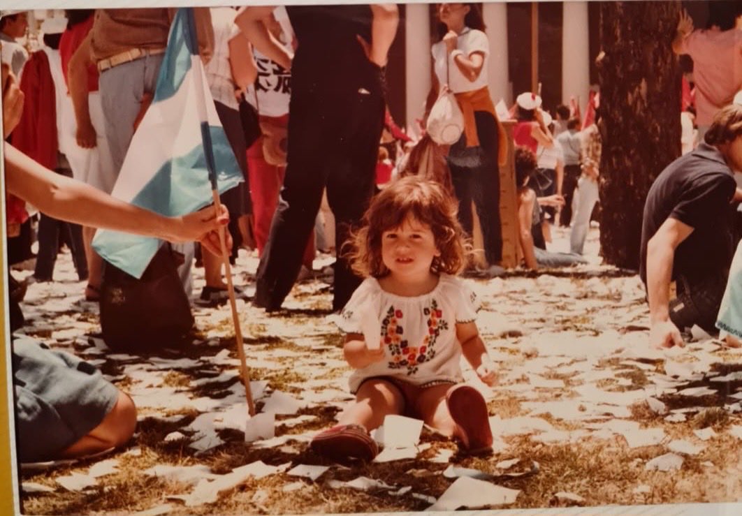1983. Asunción de Raul Alfonsín a la Presidencia de la Nación. Yendo a la PLAZA con nuestra hijita Lucrecia, 2 añitos. Recuperamos la DEMOCRACIA después de la feroz Dictadura Civico-Militar. Hace 40 años!! No la vamos a entregar. La captura maravillosa de ese momento… R. Romano