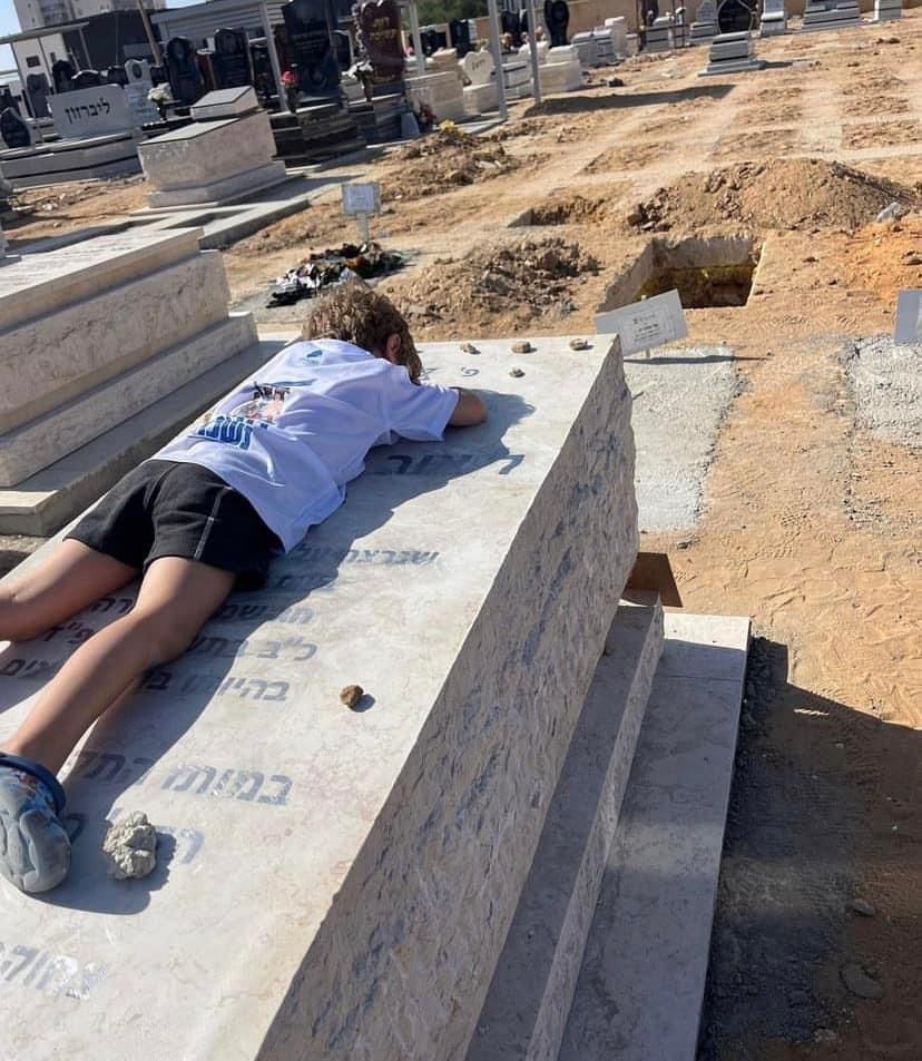StandWithUs's tweet image. 'I want to kiss dad.' In the aching stillness of grief and longing for a presence now absent, a child lies on the grave of his father who was massacred by #Hamas terrorists on October 7th.
#HamasMassacre