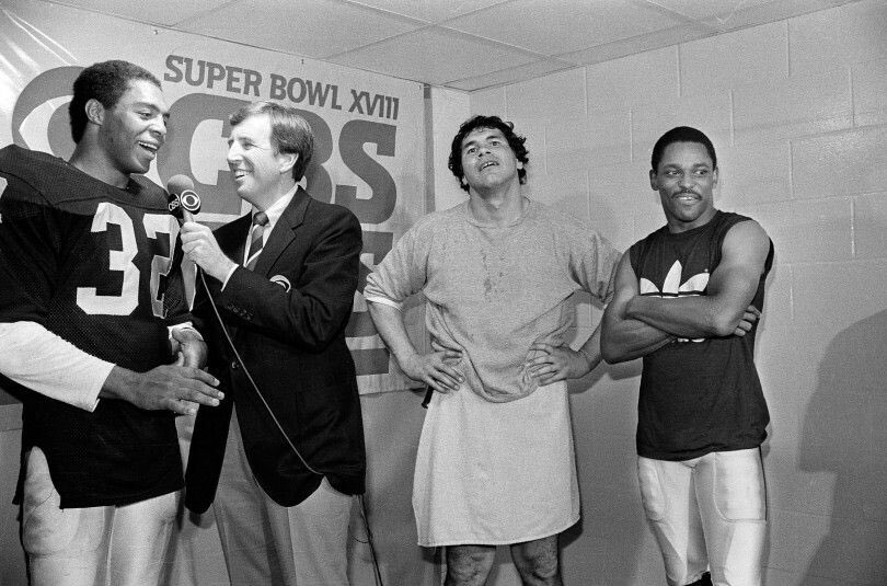 Marcus Allen, Jim Plunkett and Cliff Branch of the Los Angeles Raiders with announcer Brent Musberger post game after Super Bowl 18. #Raiders #MarcusAllen #JimPlunkett #CliffBranch #football #BrentMusburger