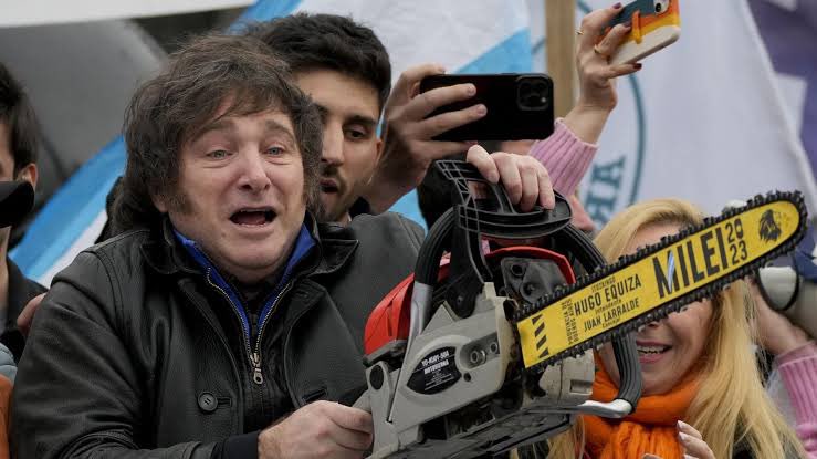 SamuelBraun's tweet photo. Amigos, não entrem nessa de “não dura dois anos”. Primeiro que em dois anos se pode destruir muito, segundo porque ele é mais competente e preparado que Bolsonaro - que mesmo matando 700 mil terminou o mandato e segue livre.

Milei provavelmente irá trair muito do que prometeu ou insinuou com os discursos efusivos. E em outras áreas, irá enfrentar a dura realidade de que a negação da razão humana aplicada à organização social, o Estado, é incompatível com a gestão de 47 milhões de vidas.

Logo após assumir a presidência, Milei irá enfrentar parcelas da dívida criada por Macri, seu apoiador, junto ao FMI. Prometeu recentemente que fará ataques aos direitos dos cidadãos ainda mais duros que o FMI pediu.

Descobrirá algo que ele mesmo viu acontecer no país nos anos 90, mas que a doutrinação liberal inverteu: a dolarização não só não é positiva, e sim desastrosa, como não se dá num passo de magia pela mão invisível do mercado. Propor dolarizar um país com dependência externa e balança comercial negativa é de reprovar aluno no primeiro período de economia.

Irá, sobretudo, enfrentar o desafio de descumprir as promessas de motosserra, símbolo de corte de serviços públicos, direitos civis e políticas públicas de mitigação da desigualdade. Alguma crueldade fará, e milhões irão sofrer. Mas como todas as promessas de arrocho, “não dá bilhão” e não tem qualquer eficácia econômica.

Na França, Reino Unido, Espanha, Portugal, e vários outros, nenhuma parabenização ao eleito na Argentina. Uma demonstração de desprestígio pro país e sua escolha. No geral, elogios apenas dos países mais agressivos na política econômica liberal e/ou membros do The Movment - a internacional reaça.

E nessa seara, das relações internacionais, Milei terá de escolher: ou se isola escondendo a Argentina num tipo de gueto global até Trump ser eleito, contando (como
Bolsonaro) em ser escolhido como aliado estratégico, ou se conduzirá errático entre a verborragia e a necessidade de priorizar Brasil, China e Rússia, os comunistas do BRICS, e os vizinhos do Mercosul que ele prometeu abandonar.

A contradição está na base: elegeram para administrar o Estado alguém que propõe acabar com o Estado. Certo que não acabará com ele, por ser impossível, mas o problema está em ser, assumidamente, um mal administrador: comprometido em atacar, e não defender, aquilo que administra.