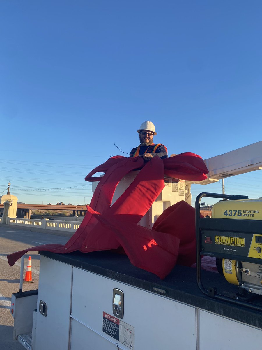 Tempegov's tweet photo. Making our city beautiful for the holidays, Tempe’s Streets team is out this morning hanging the traditional red bows on the Mill Avenue bridges. #tempe #millave https://t.co/kQGn3WqwD7