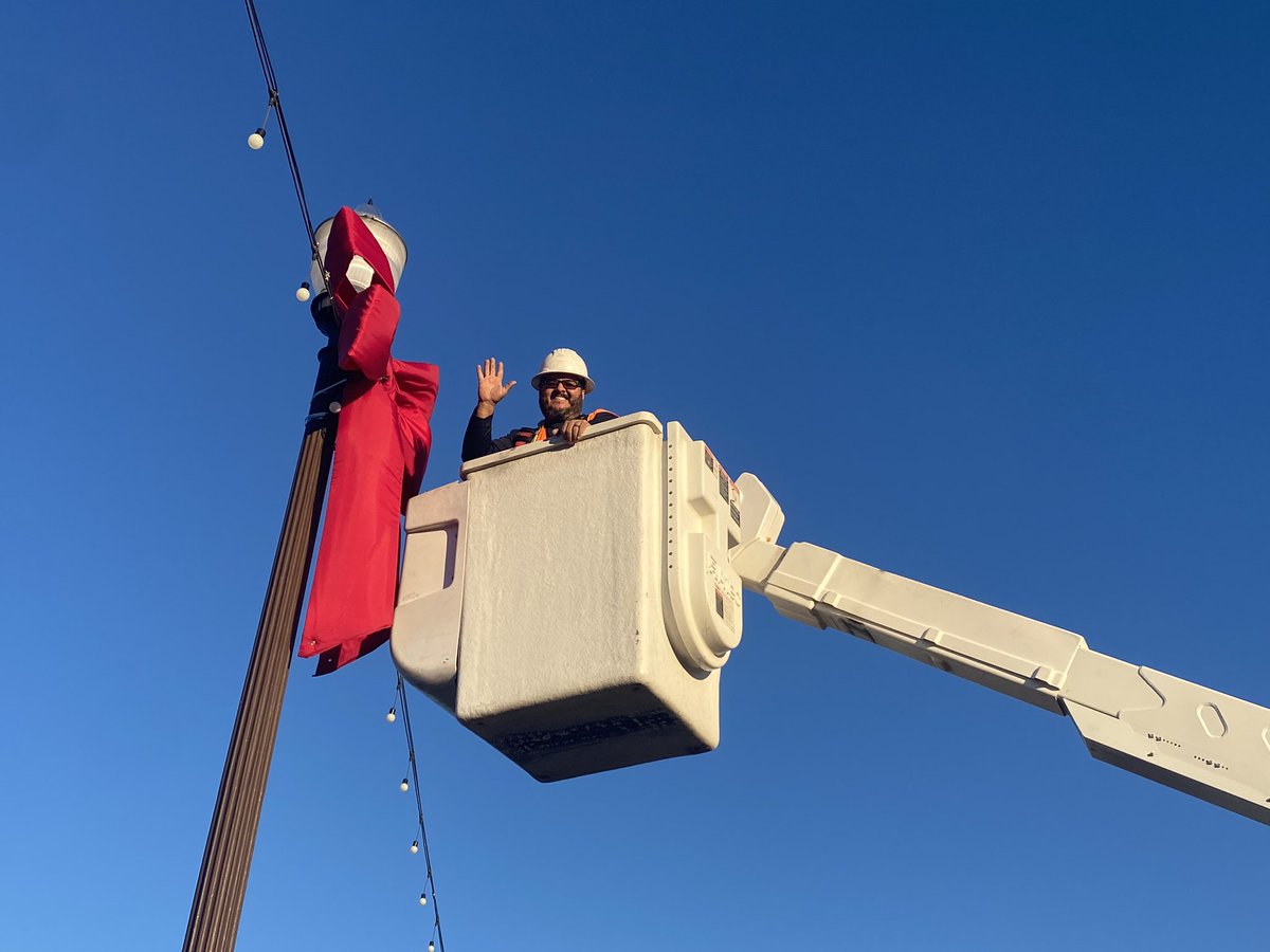 Tempegov's tweet photo. Making our city beautiful for the holidays, Tempe’s Streets team is out this morning hanging the traditional red bows on the Mill Avenue bridges. #tempe #millave https://t.co/kQGn3WqwD7