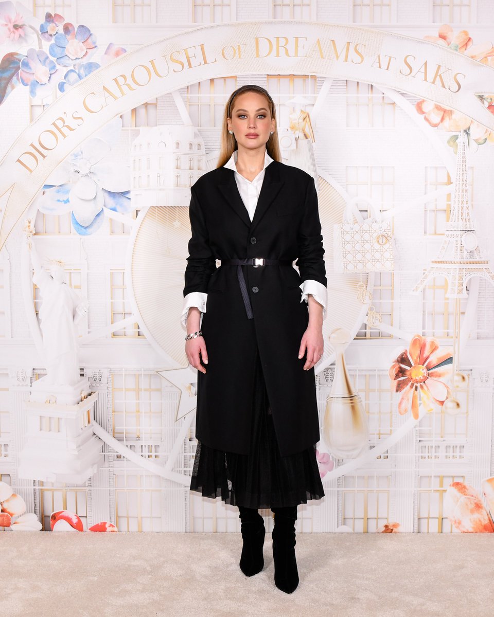 Contrasted distinction. Actress and House friend Jennifer Lawrence inaugurated Dior's Carousel of Dreams at @Saks in a chic black wool coat, white shirt, and black silk skirt by Maria Grazia Chiuri. #SaksxDior #StarsinDior