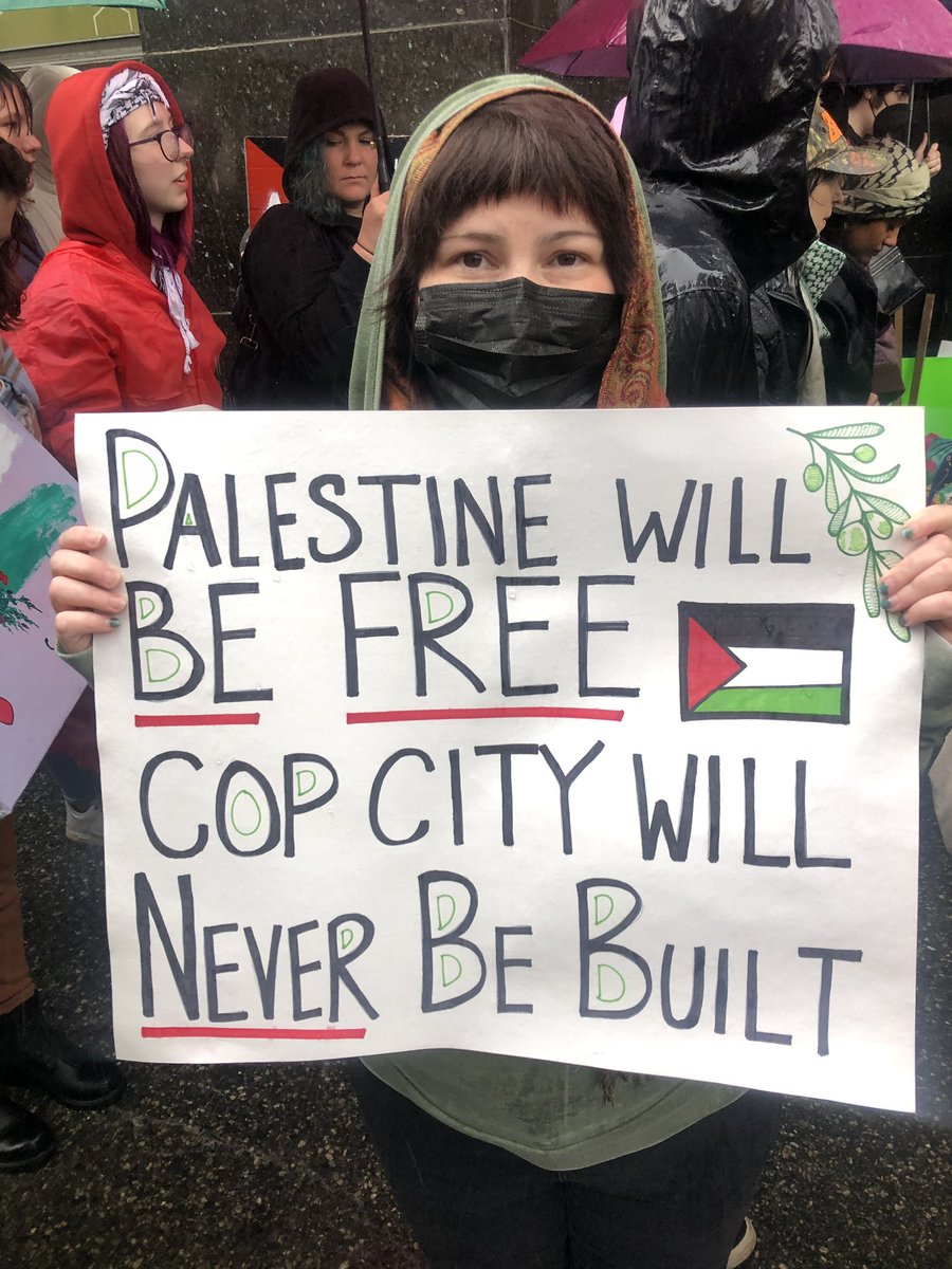 UE Local 696 member Crystal Grabowski holds sign that says Palestine will be free. Cop city will never be built