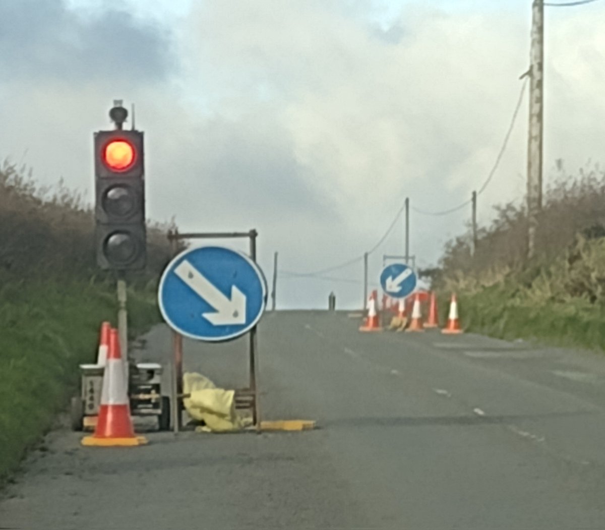 TMEL001's tweet photo. @DwrCymru it's now a week since I tweeted re traffic lights with NO works taking place. I DM'd all the details and my local depot called Friday to clarify the situation. Contractor was to remove them. Lights remain insitu. Several cones are missing due to high winds. Pics today https://t.co/twV00HnpwU