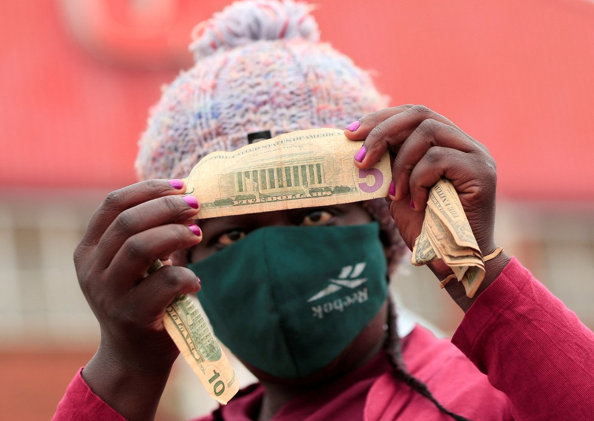 Studio7VOA's tweet photo. #ZimLife: An illegal money changer checks old U.S. dollars at a marketplace in Harare, Zimbabwe. (Reuters) https://t.co/IjxKnKVTSA