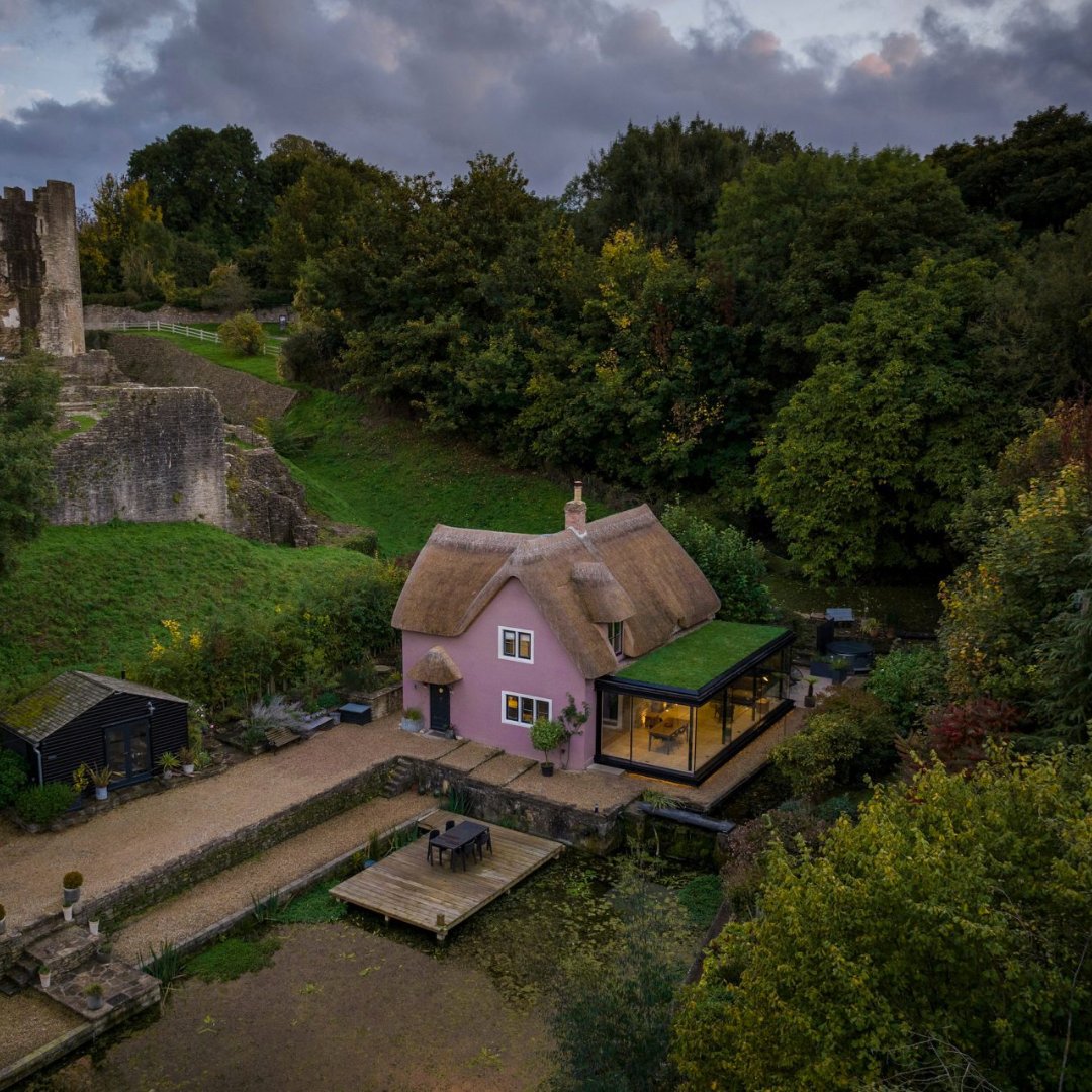 British studio Greenaway Architecture has added a minimalist glass extension to a 15th-century thatched cottage alongside Farleigh Hungerford Castle. The extension was built from a thin steel frame with glass-to-glass corners to give almost unbroken views to the pond. #PinkFriday