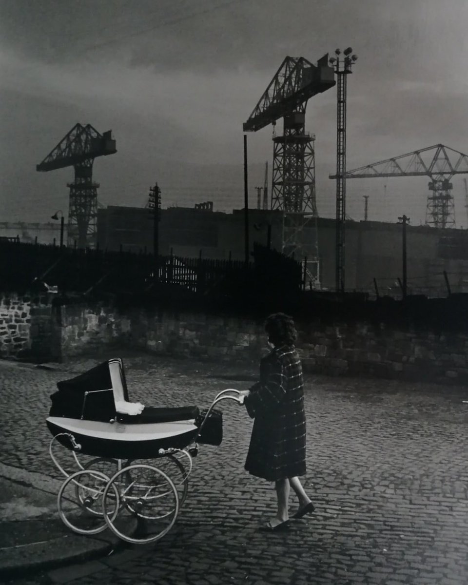 Mother with pram walking past Swan Hunters shipyard, Wallsend in 1962 by Colin Jones.