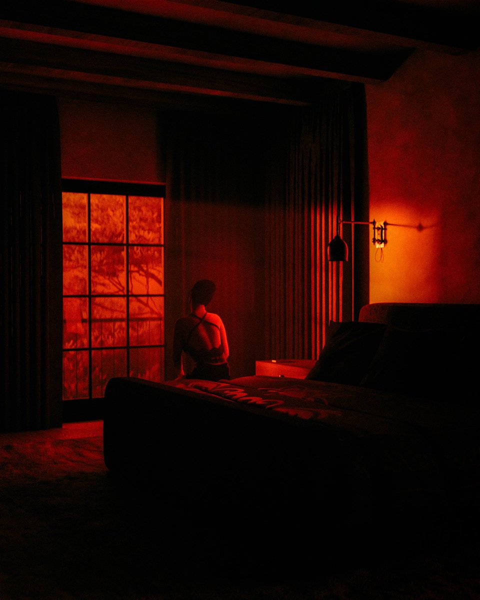 In a room washed red, she wonders — is she alone or just lost in thought?