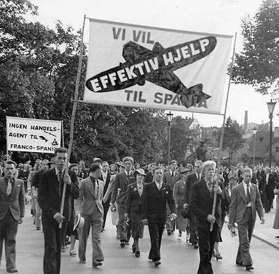 Civil_War_Spain's tweet photo. Oslo, 1937. Demonstration demanding "more effective aid for Spain". Smaller banner to left is calling for a boycott of fish sales/trade to Franco's Spain. We have a tin found in Republican trench on Segre front of Norwegian herring, possibly from food aid from Norway trade unions https://t.co/0F7qr3GFox