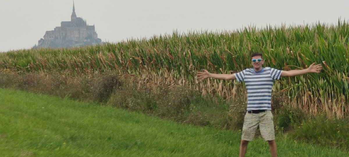 JulCorn's tweet photo. @CornucopiasGame this is me in a corn field in France. Mont-Saint-Michel in the background https://t.co/HIgA4LZ1FF