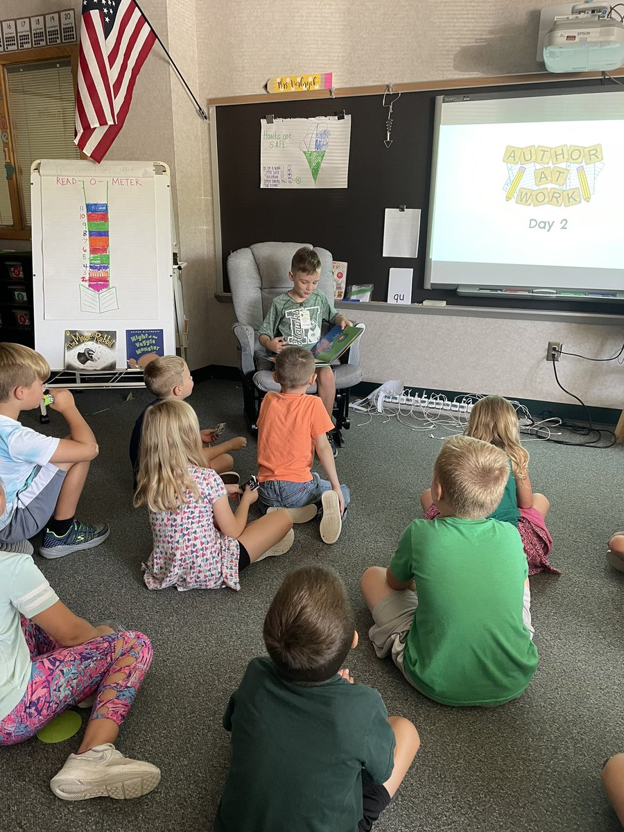 Student of the week celebrating by reading a book of his choice to friends.