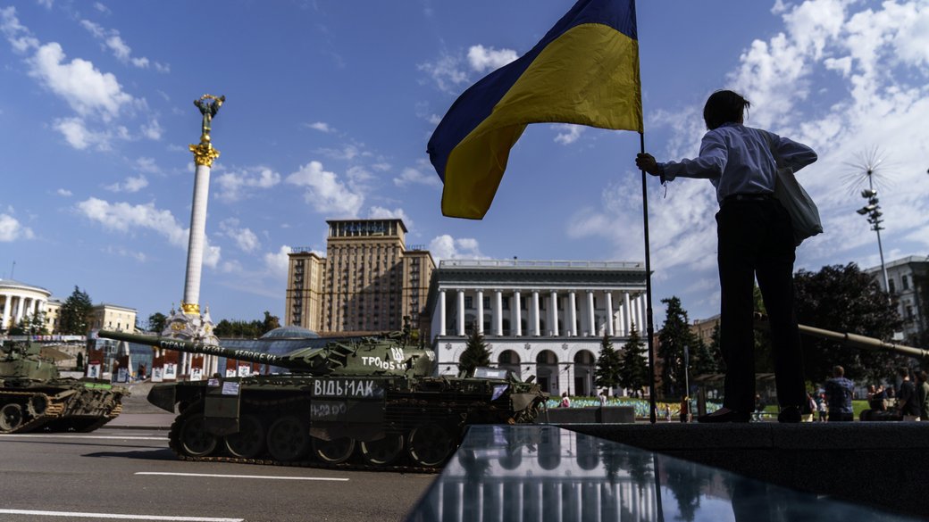 ukraine_world's tweet photo. A woman holds Ukrainian flag, while looking at the destroyed Russian military vehicles at Maidan Nezalezhnosti, the central square of Kyiv, 23 August. 

📸AP https://t.co/x3vRHk6nnI