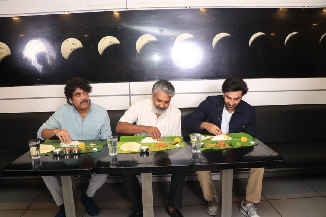 HydTimes's tweet photo. .@iamnagarjuna,@ssrajamouli &amp; #RanbirKapoor enjoy traditional bhojanam in #Chennai while promoting #Brahmastra 

#Nagarjuna #SSRajamouli #AliaBhatt #TeamBrahmastraInChennai #Bollywood #Tollywood https://t.co/h5PkTD17wK